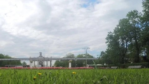 Flowerbed and monorail in front of arch timelapse 스톡 동영상 78015628