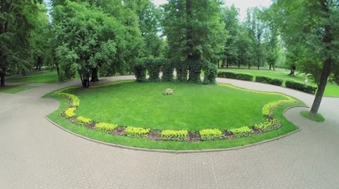 Flowerbed in park with paved paths at summer day. Aerial view Stock Footage 46294519