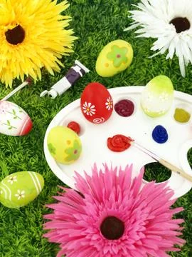 Flowers and Easter eggs on palette Stock Photos