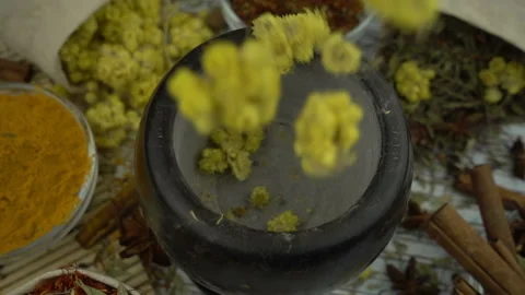 Flowers and herbs falls down into the granite mortar in slow motion. Healthy and Stock Footage 133193238