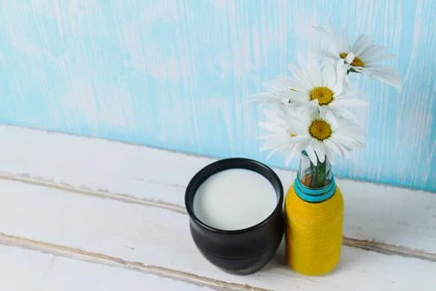 Flowers and milk on the table Stock Photos