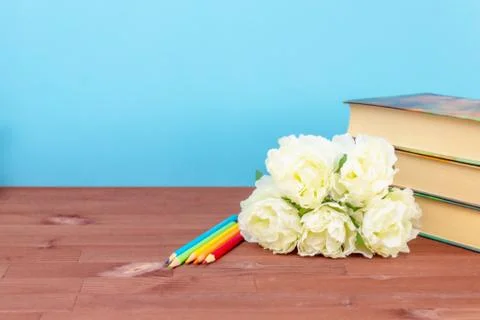 Flowers, colored pencils on the table, preparing for school on the blue black Stock Photos