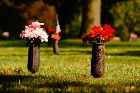Flowers-with-Flag-at-Graves Stock Photos