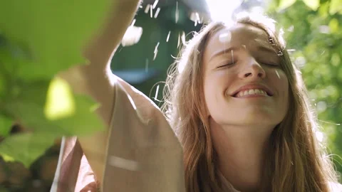 Flowers jasmine fall on the face of a young girl. sunbeams and glare, slow Stock Footage 135323622