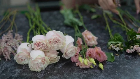 Flowers of a rose and eustoma lie on a table of the florist when making a Stock Footage 123653266