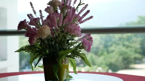 Flowers in a vase on a rotating table next to the window Stock Footage 103492686