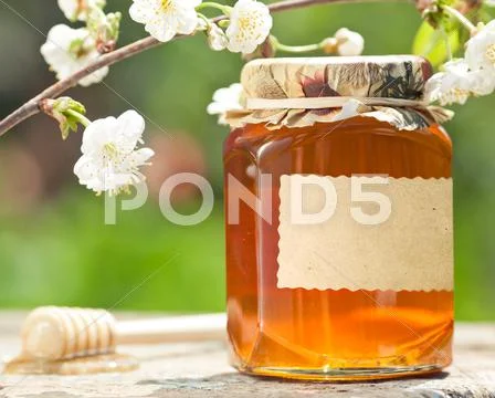 Flowery honey in glass jar Stock Photos