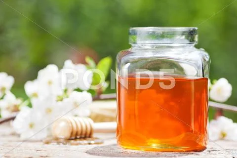 Flowery honey in glass jar Stock Photos