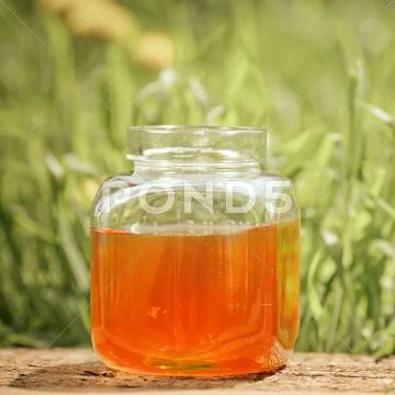 Flowery honey in glass jar Stock Photos