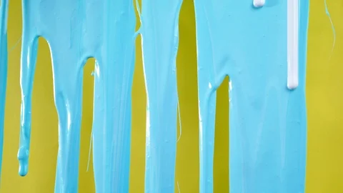 Flowing blue paint on yellow background in 4K Stock Footage 104034389