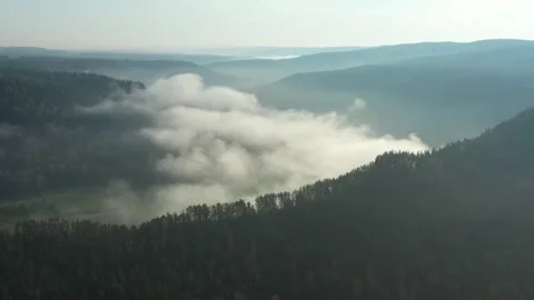 Flowing clouds gracefully drifting over a mountain valley Vídeo Stock 291932085