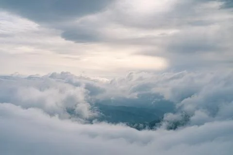 Flowing clouds in winter mountain at sunset Stock Photos