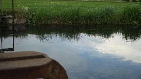 Flowing in cold river, rusty steel element reflection in water Video stock 92694576