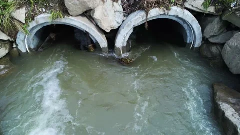 Flowing flooded mountain river through concrete pipes Stock Footage 156510554