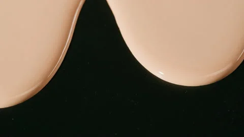 Flowing foundation tone on black background. Brown cream texture close-up 스톡 동영상 178616163
