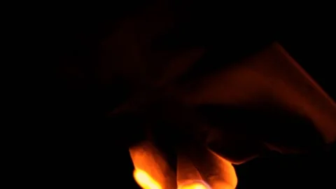 Flowing paper burning in the dark on grass, closeup slow motion. Video stock 131474046