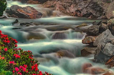 Flowing river down the rocks as long exposure filmed in the beautyful autrian Stock Photos