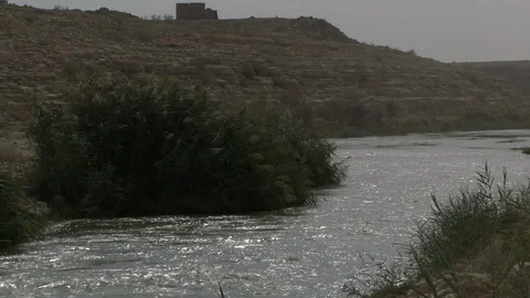 A flowing river, with mountains in the background. Stock Footage 120061999