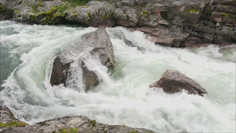 Flowing river over large rocks in Norway's natural landscape Stock Footage 316597017