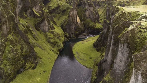 Flowing river widening below mountains aerial Stock Footage 264634145