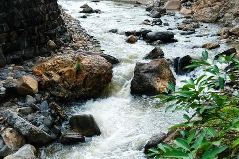 Flowing stream over rocks in a natural landscape Stock Photos