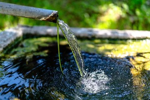 Flowing Water from Rustic Pipe into Basin Stock Photos