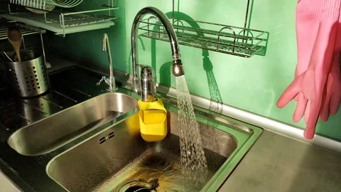 Flowing water from the tap in the kitchen. Stock Footage 106580574
