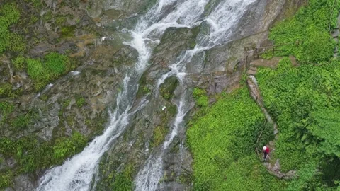 The flowing waterfall is surrounded by stone walls. Stock Footage 311749621