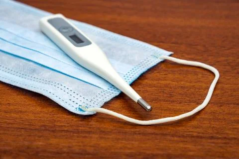 Flu Mask with a Thermometer Stock Photos