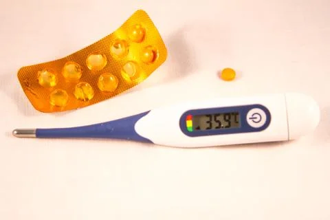 Flu pill with electronic thermometer Stock Photos
