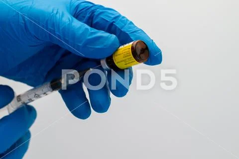 Flu shot. Hands in blue gloves prepare to give a shot on white background. Stock Photos