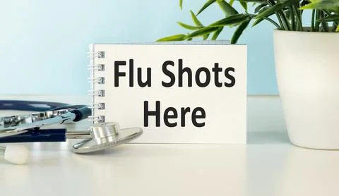 Flu Shots Here text written on a notepad . The concept of coronavirus. Stock Photos