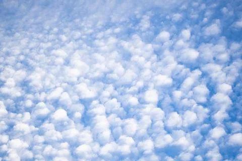 Fluffy altocumulus clouds forming a pattern across a blue sky Stock Photos