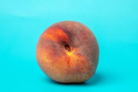 A fluffy and appetizing peach on an intense blue background, Stock-Fotos