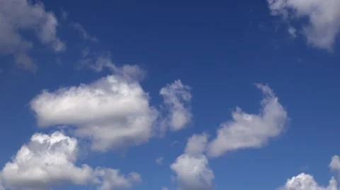 Fluffy cirrus and cumulus clouds in blue sky with sun shining behind. Stock Footage