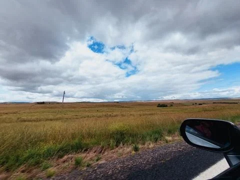 Fluffy cloud and green fields Stock Photos