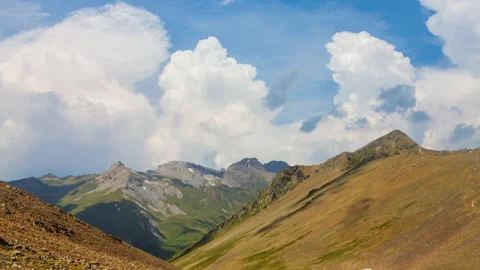 Fluffy clouds above a mountain backbone Stock Footage 339058649