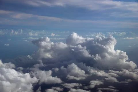 Fluffy Clouds in a blue sky above the ocean Stock Photos
