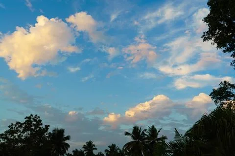Fluffy clouds in the blue sky at dawn Stock Photos