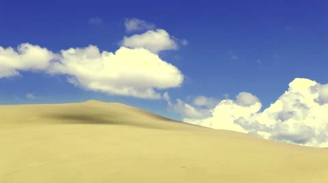 Fluffy clouds, blue sky, flowing over sand dune Stock Footage 44275276