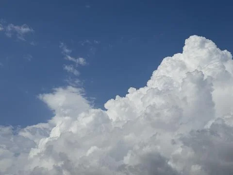 Fluffy clouds in blue sky over scenic landscape Stock Photos