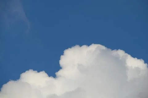 Fluffy clouds on deep blue sky background. Stock Photos