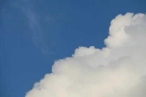 Fluffy clouds on deep blue sky background. Stock Photos