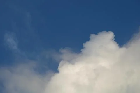 Fluffy clouds on deep blue sky background. Stock Photos