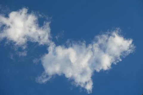 Fluffy clouds on deep blue sky background. Stock Photos
