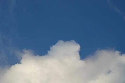 Fluffy clouds on deep blue sky background. Stock Photos