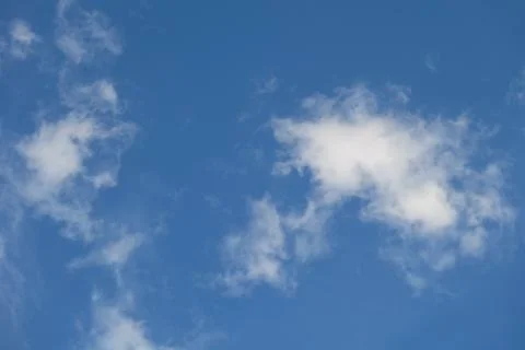 Fluffy clouds on deep blue sky background. Stock Photos