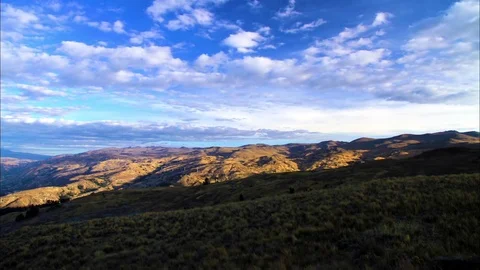 Fluffy clouds floating over mountain and landscape Stock Footage 77444850
