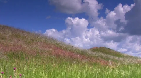 Fluffy clouds flying above green hills Video stock 436775