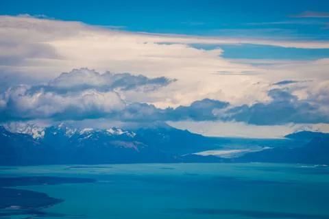 Fluffy clouds hover over the bay and the mountains. Shevelev. Stock Photos